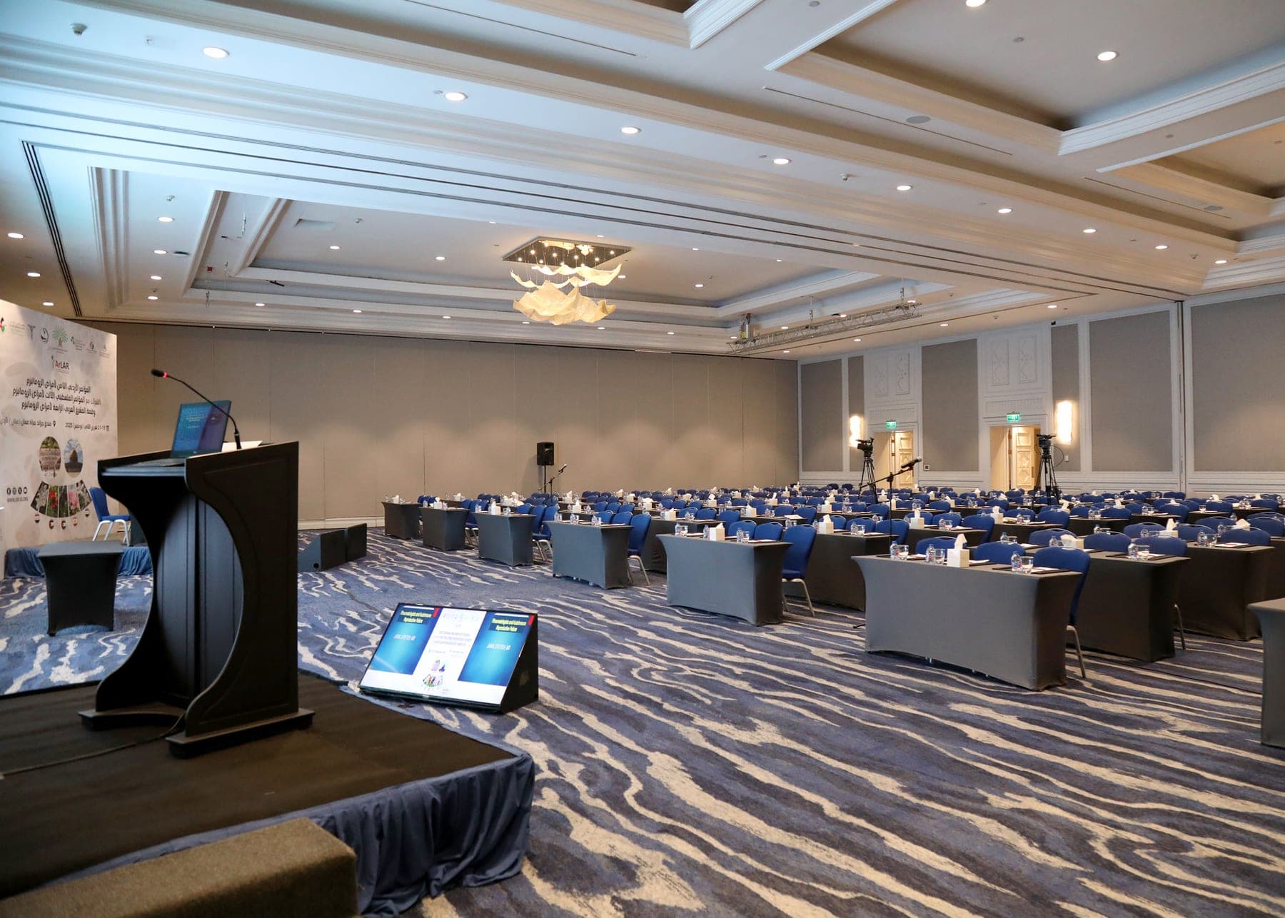 The main hall set for the 8th Jordanian Rheumatology Congress at the Grand Hyatt Amman, 2025, with the speaker's podium in the foreground